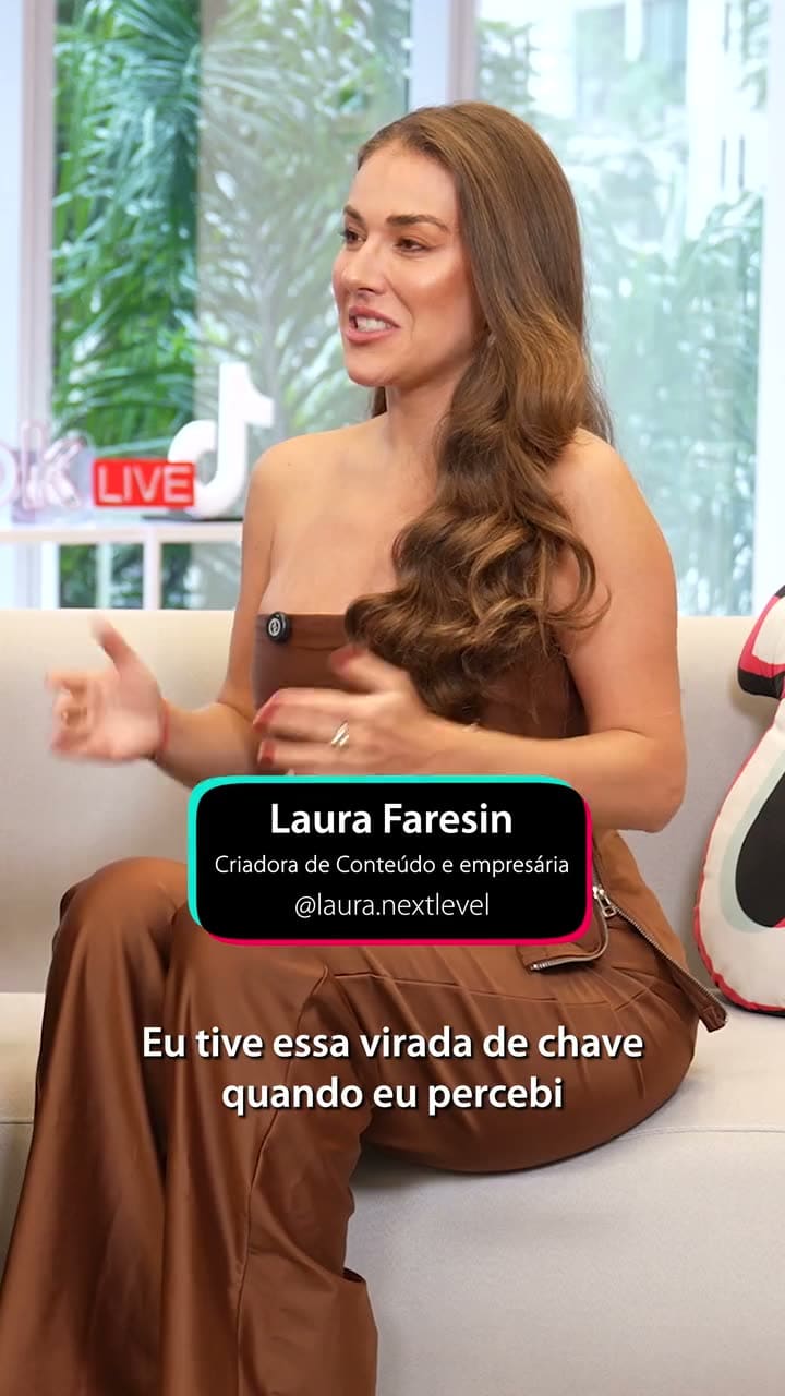 Laura Faresin gesticulando durante a entrevista no sofá do estúdio do TikTok Live