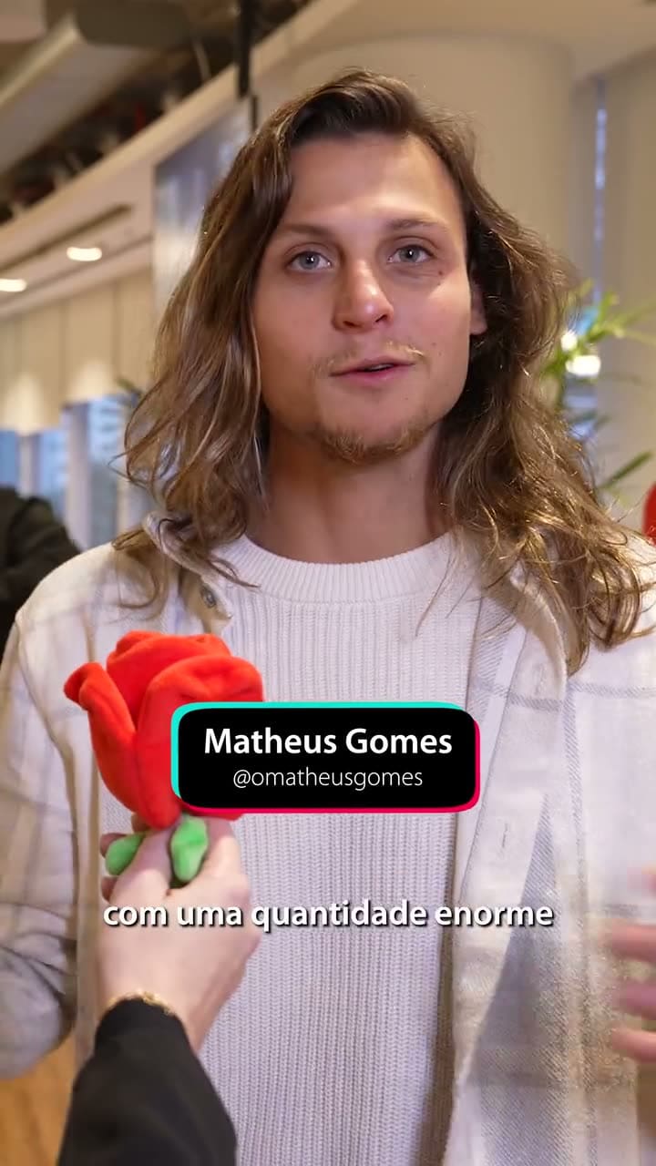 Matheus Gomes respondendo a uma pergunta com o microfone coberto por uma pelúcia vermelha em forma de rosa